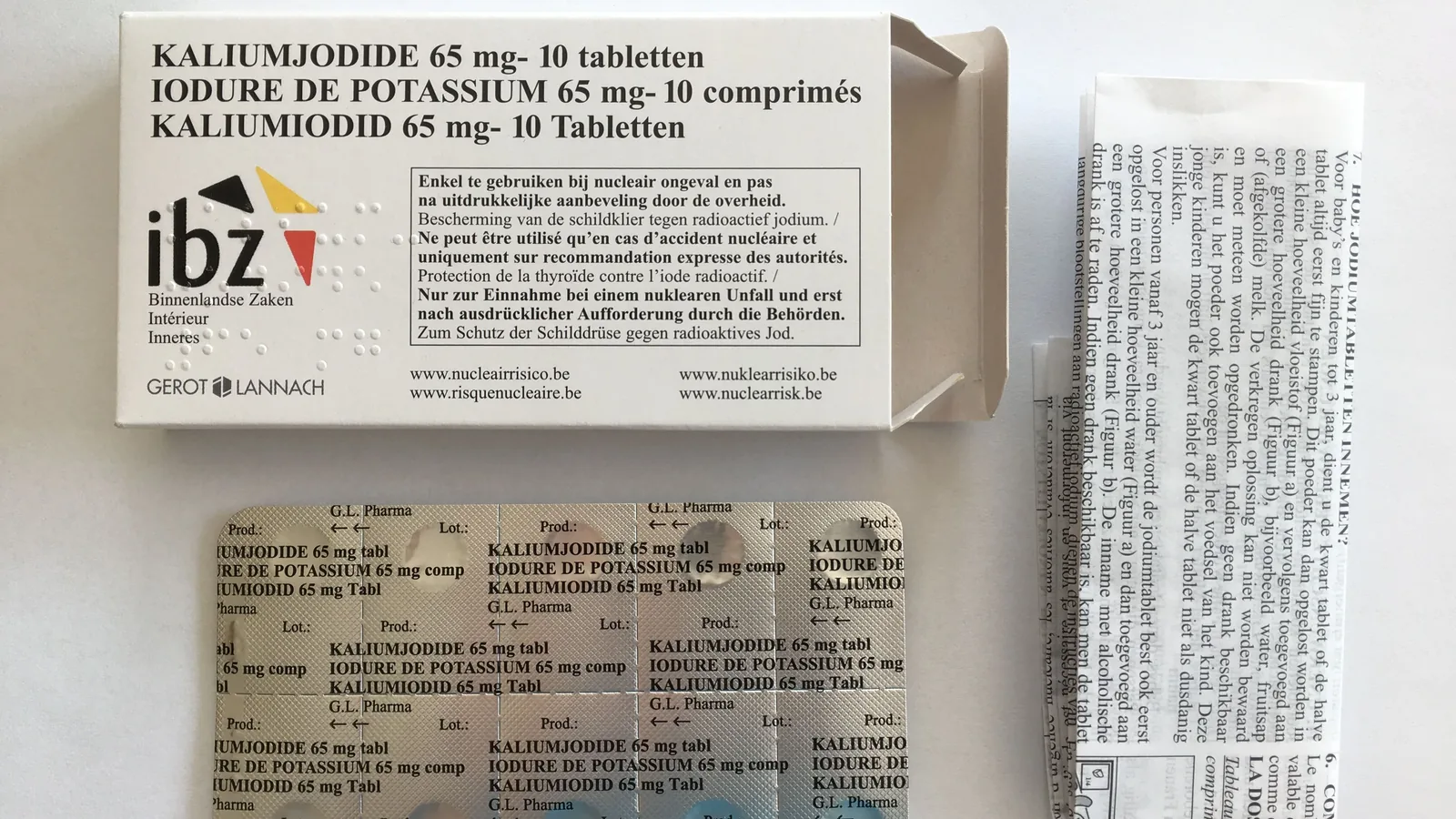 Eine geöffnete Packung mit Kaliumiodidtabletten und Blisterstreifen liegt auf einer neutralen Unterlage.