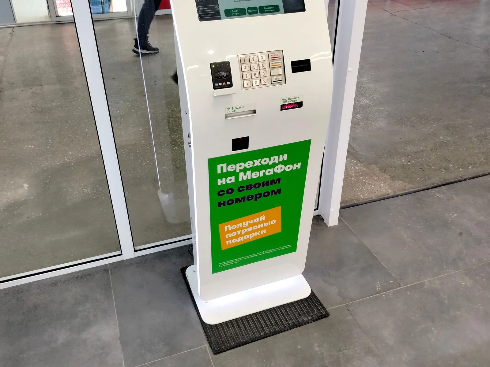 Ein elektronisches Zahlungsterminal mit Bildschirm, Kartenleser und Zifferntastatur in einem Geschäft.