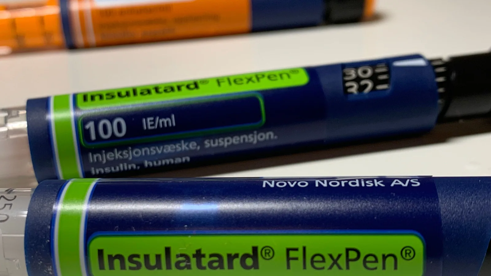 Mehrere Insulinpens liegen nebeneinander auf einer neutralen Unterlage.
