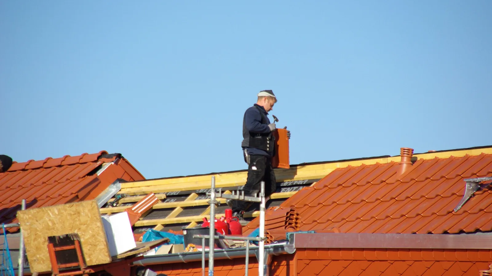 Ein Zimmermann arbeitet auf der Holzkonstruktion eines neuen Daches in Rostock.