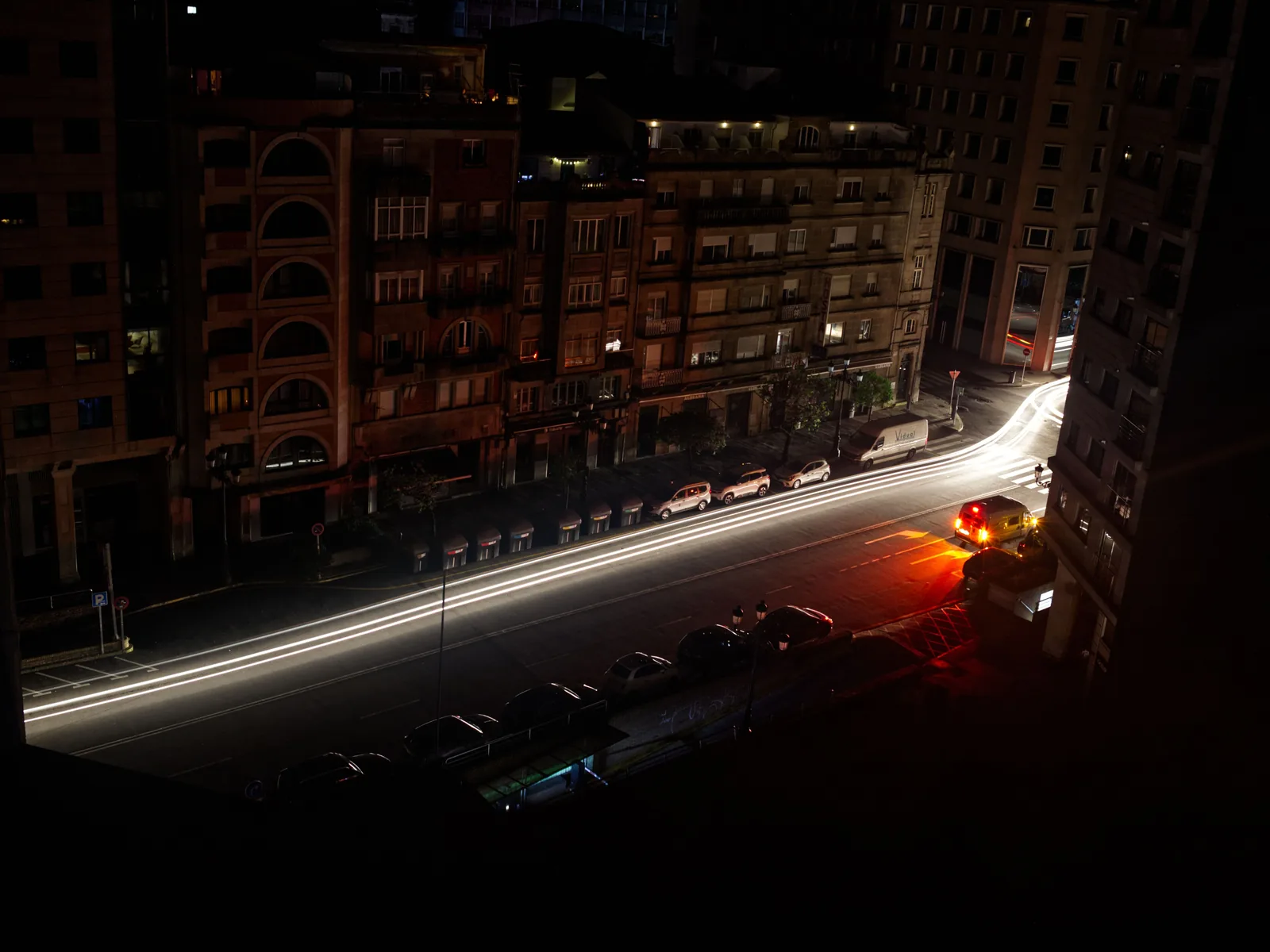 Eine zentrale Straße in Vigo liegt während des Blackouts am Abend des 28. April 2025 weitgehend ohne Straßenbeleuchtung; nur Fahrzeuge und einzelne Fenster leuchten.
