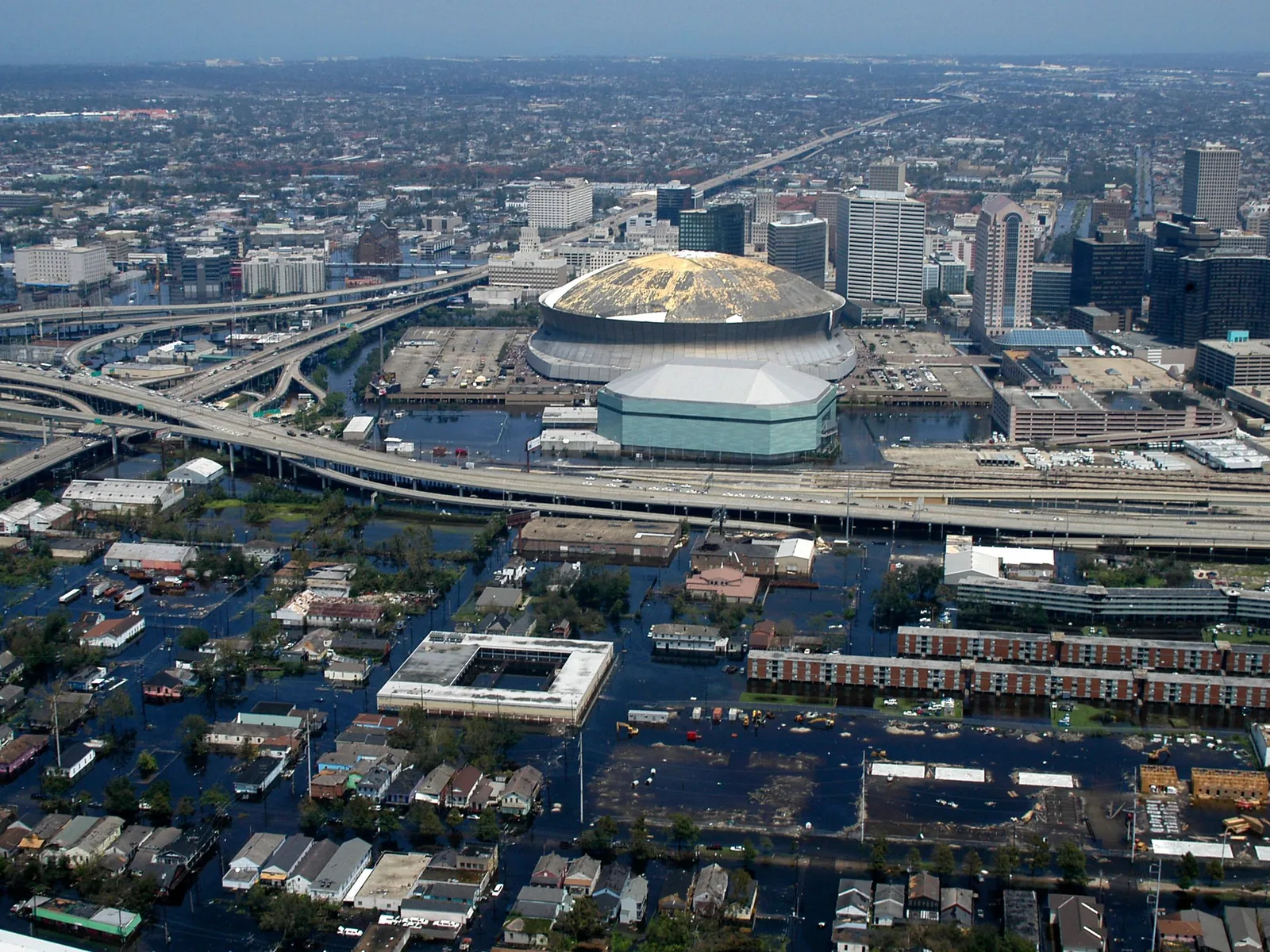 Luftbild der Innenstadt von New Orleans am 31. August 2005: In der Mitte das Stadion Superdome mit beschädigtem Dach, ringsum überflutete Straßen und Autobahnbrücken.
