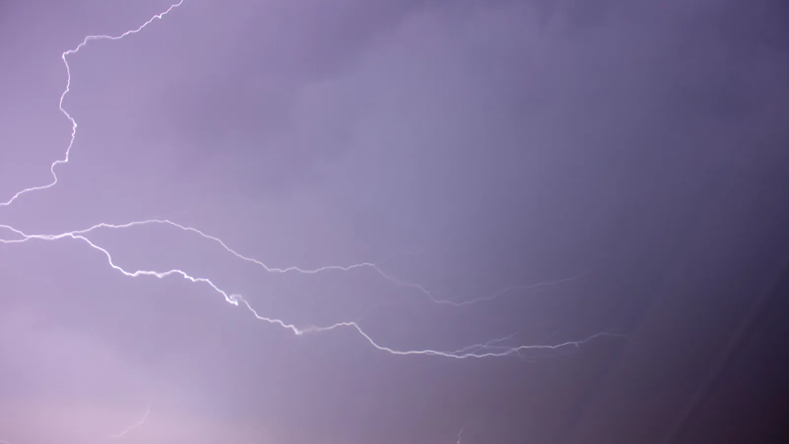 Mehrere Blitze erhellen während eines Gewittersturms den dunklen Himmel über Rheinland-Pfalz.