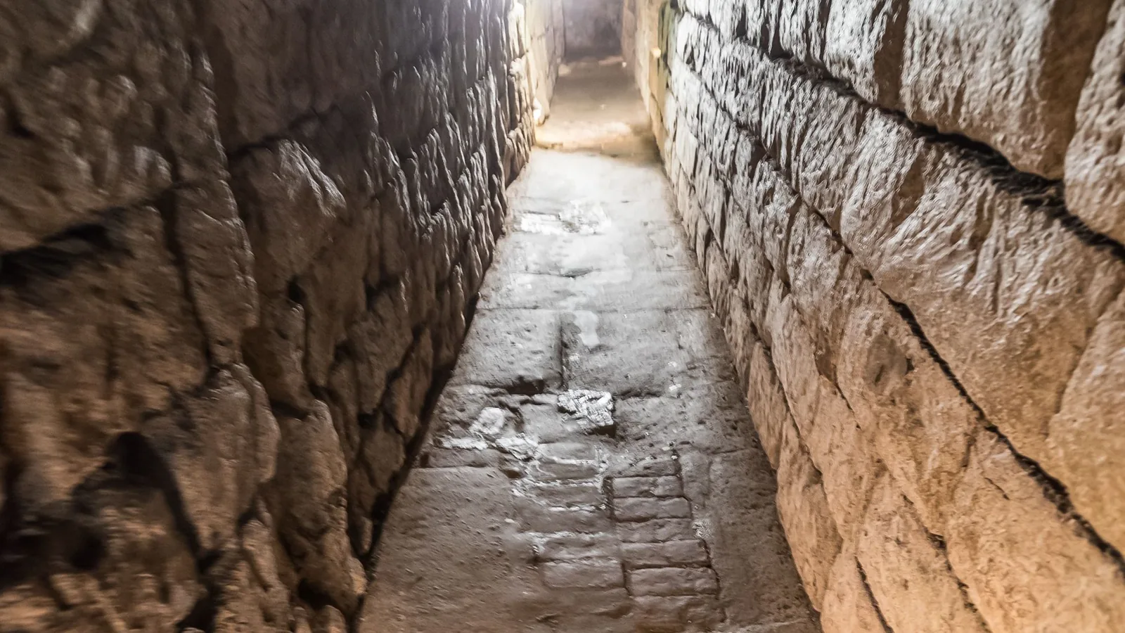 Ein begehbarer römischer Abwasserkanal in Köln mit gemauerten Steinwänden und gewölbter Decke.