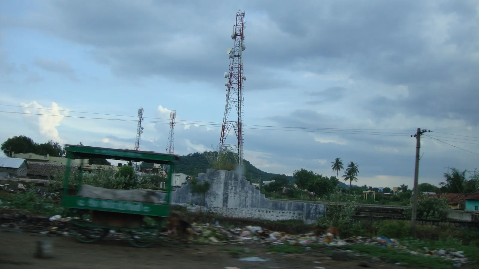 Ein freistehender Mobilfunkmast mit mehreren Antennen steht unter freiem Himmel.