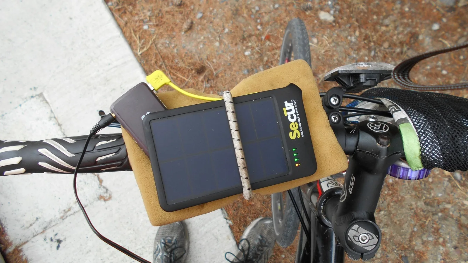 Ein tragbares Solarpanel ist mit einem Akkupack verbunden, das unterwegs elektronische Geräte mit Strom versorgt.