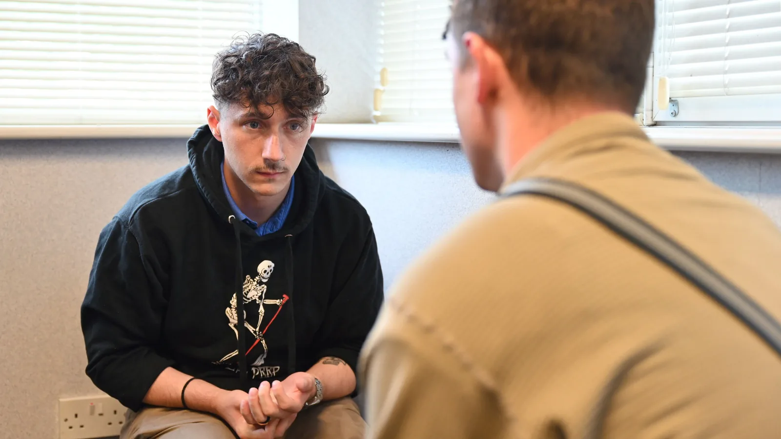 Teilnehmende eines Mental-Health-First-Aid-Kurses sitzen zusammen und üben Gesprächs- und Unterstützungsstrategien.