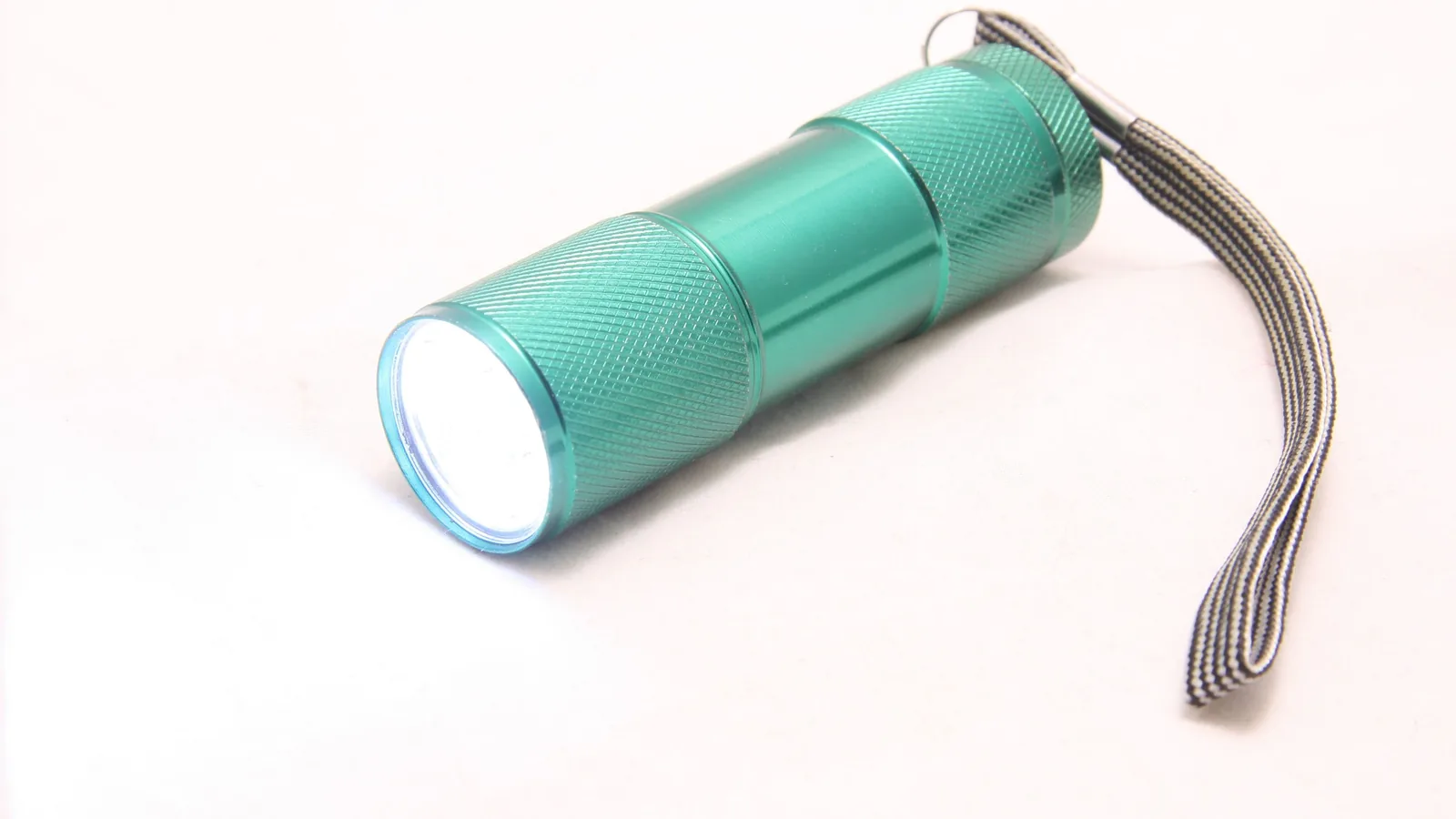 Eine eingeschaltete Taschenlampe leuchtet in dunkler Umgebung.