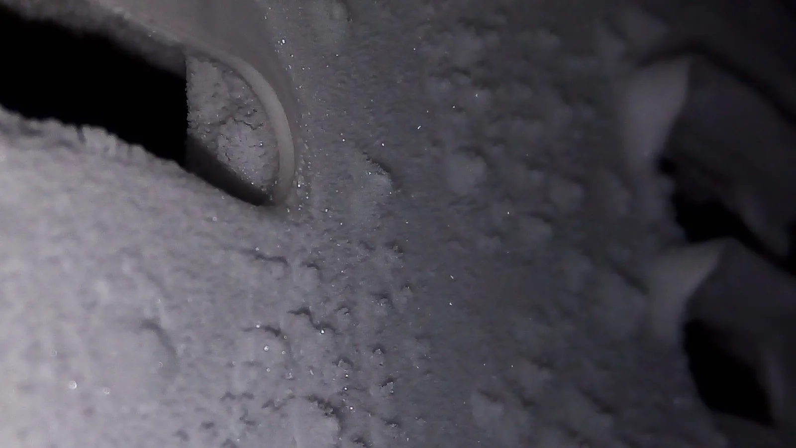 Dicke weiße Frostschichten bedecken Teile eines Gefrierfachs.