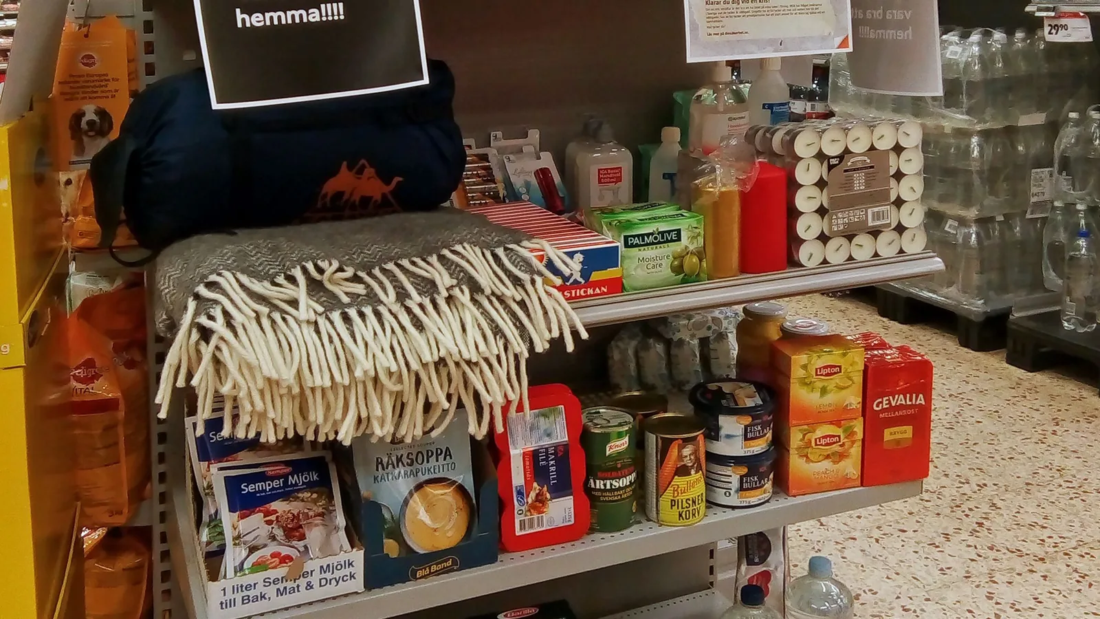 In einem schwedischen Lebensmittelgeschäft ist eine Auswahl von Gegenständen ausgestellt, die in der Broschüre Om krisen eller kriget kommer für die Krisenvorsorge genannt werden.