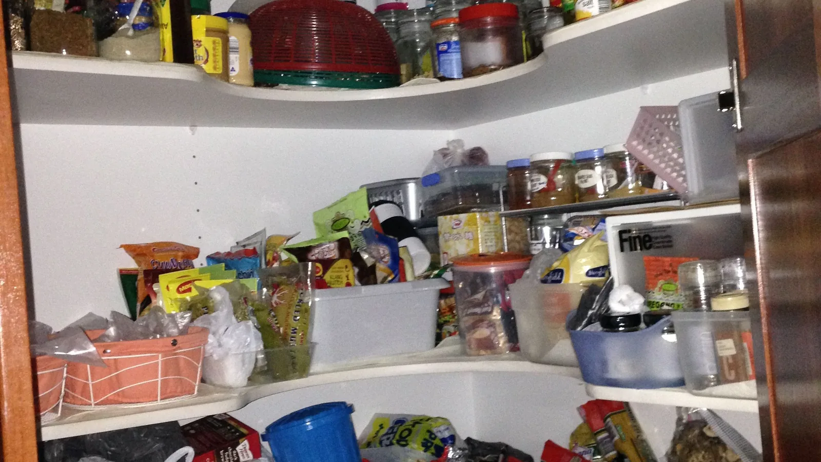 Ein geordneter Vorratsschrank enthält normale haltbare Lebensmittel in Dosen, Gläsern und Packungen.
