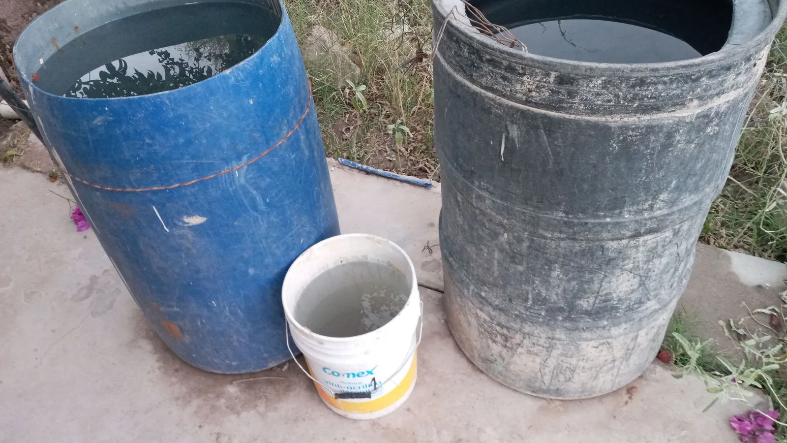 Mehrere große Kunststofffässer werden für die häusliche Lagerung von Wasser genutzt.