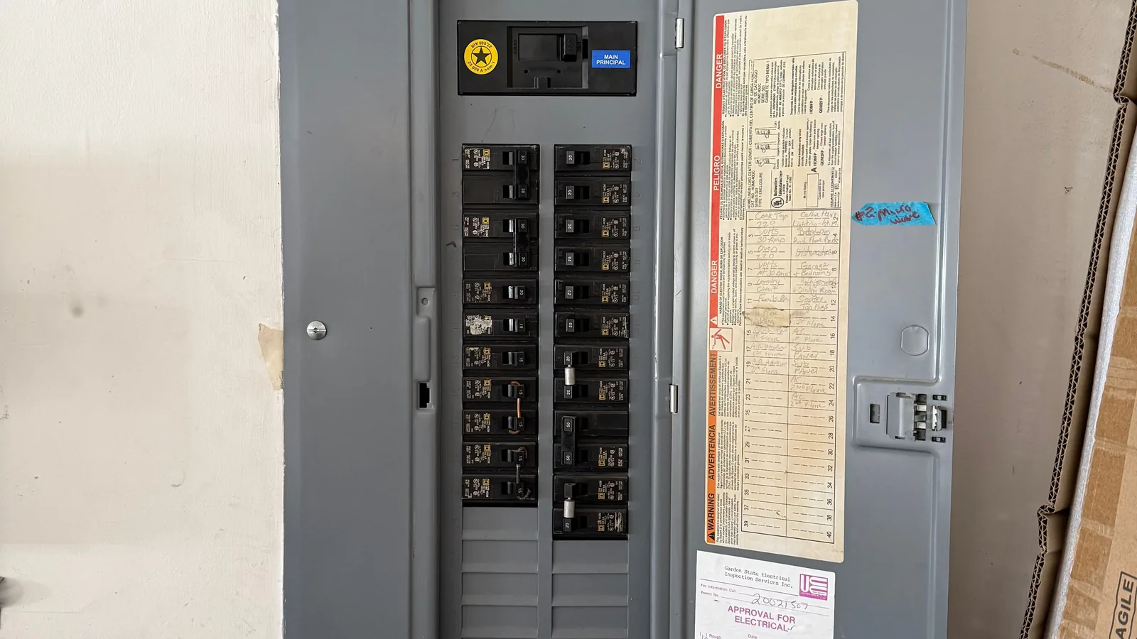 Ein geöffneter Sicherungskasten mit mehreren Leitungsschutzschaltern befindet sich in einem Wohnhaus.