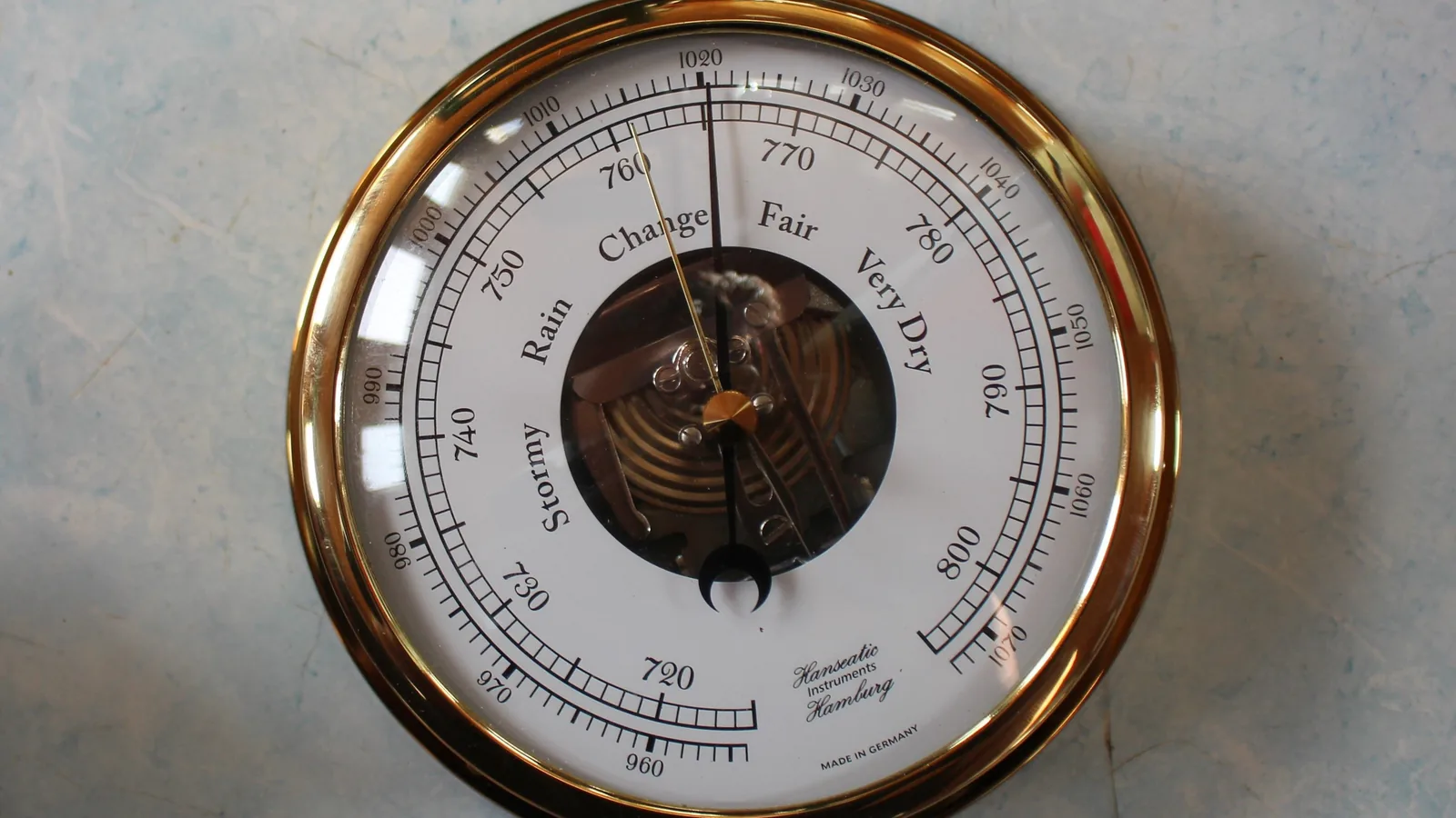 Ein analoges Aneroidbarometer mit Zeiger und Skala zeigt den Luftdruck ohne digitale Technik an.